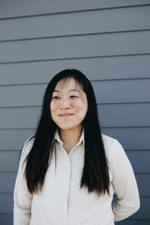 a woman smiling for a camera in front of a building