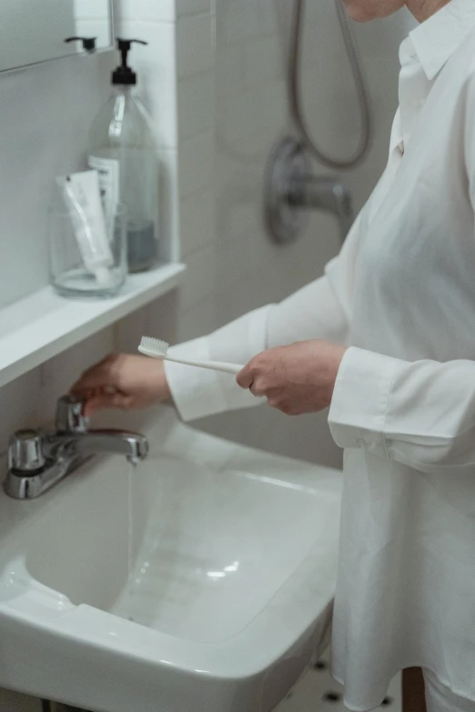 woman holding a wrench working on a sink in the bathroom