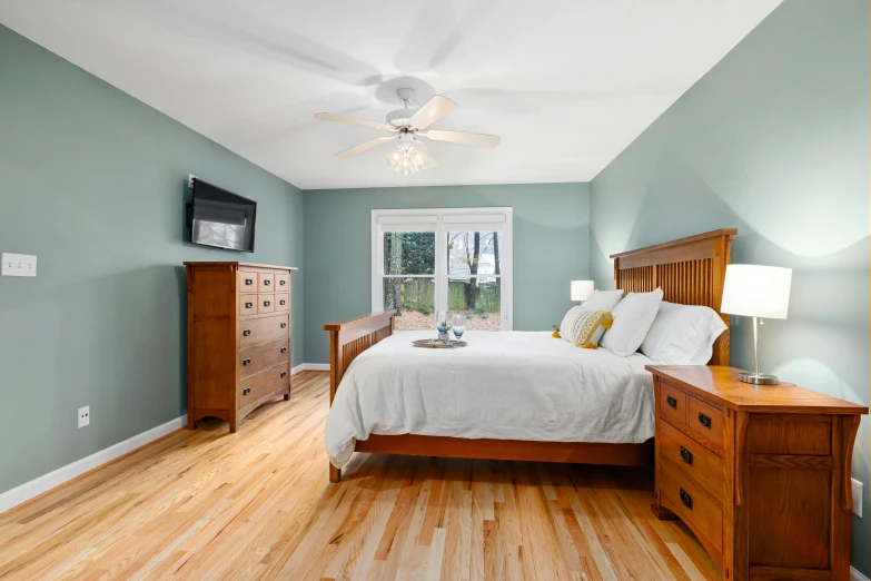 a bedroom decorated in blue with hardwood flooring