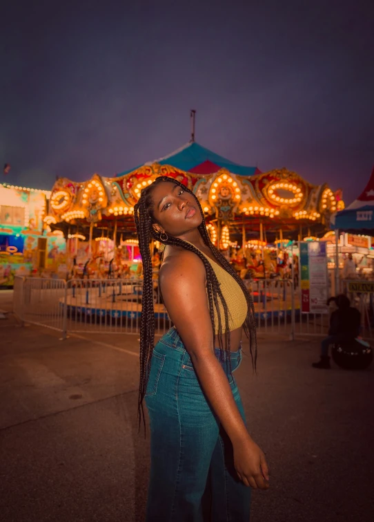 young woman with dreadlocks posing in front of a carnival ride