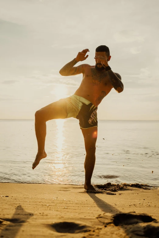 a man is doing a yoga pose on the beach