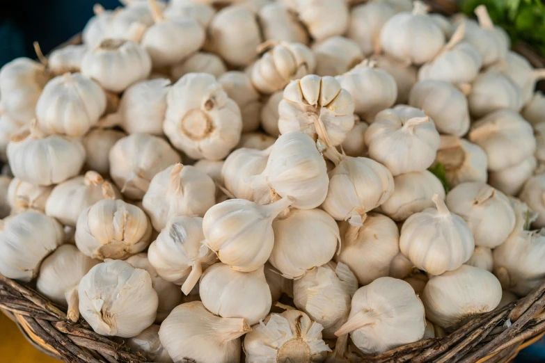 a bunch of small garlic that are in a basket