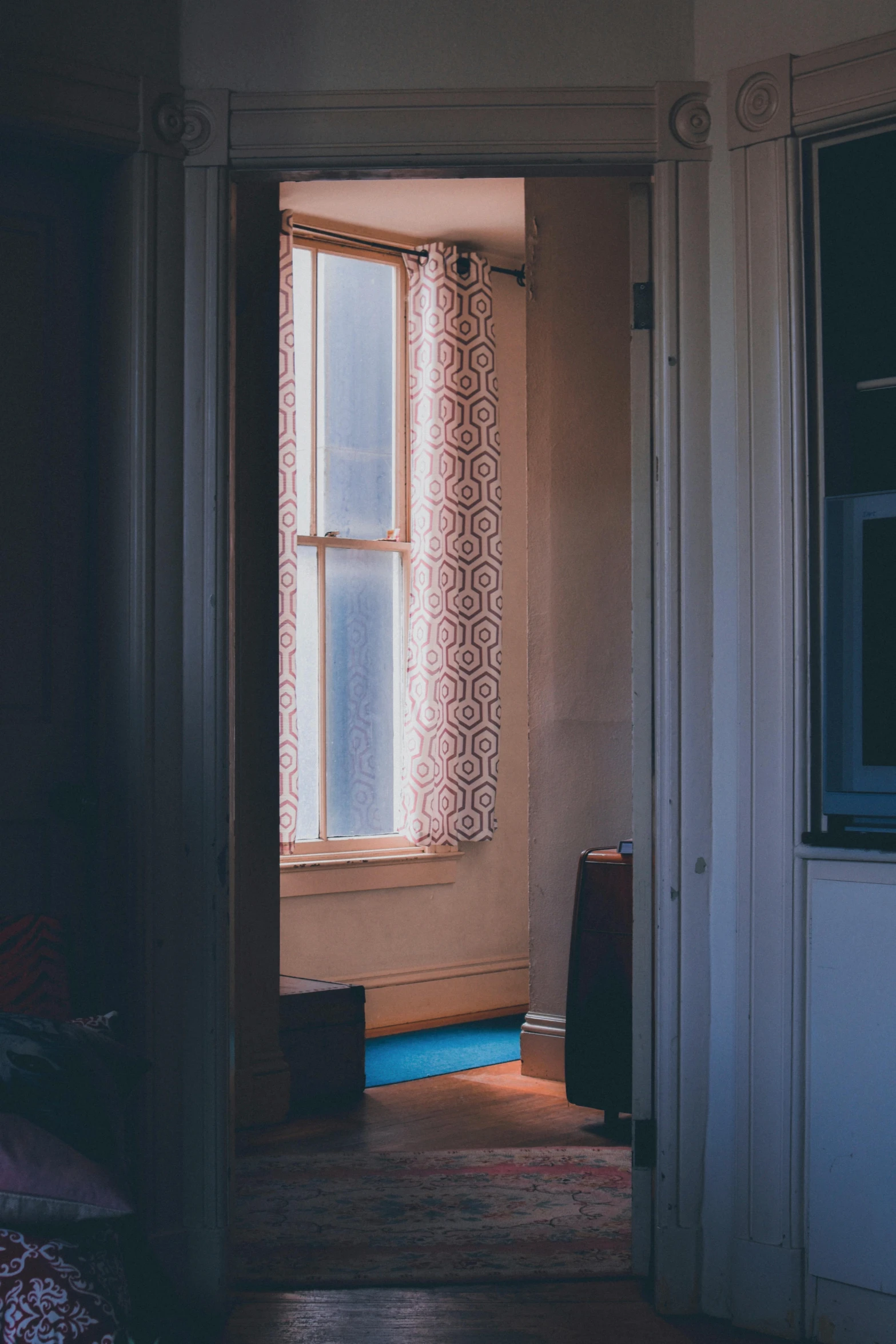 a bedroom with the light from the window shining through