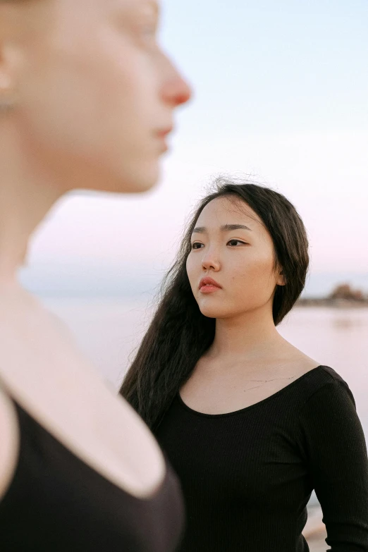 two women standing side by side looking to the side