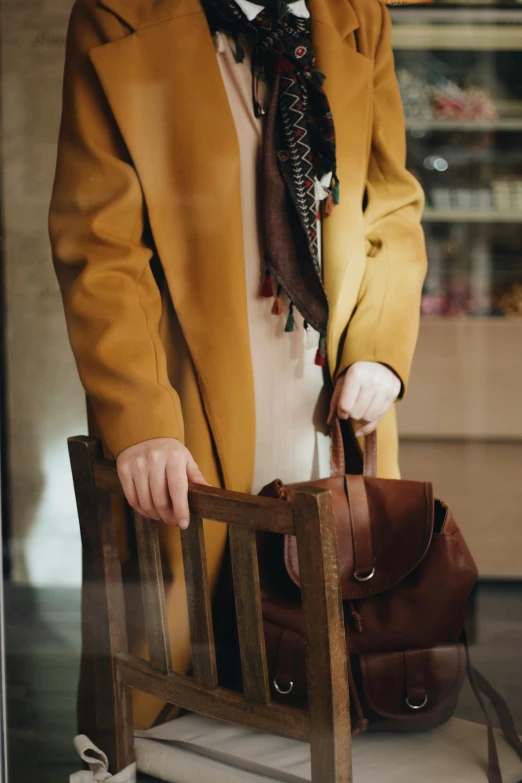 a young woman sitting on a bench while holding her brown purse