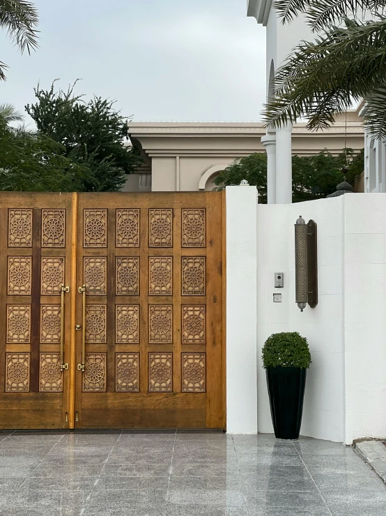 a large wooden gate next to a white building