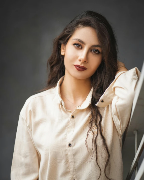 a woman is posing next to a mirror wearing a blouse