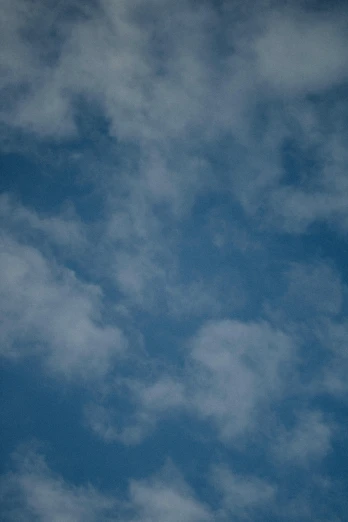 a airplane flying through a cloudy blue sky