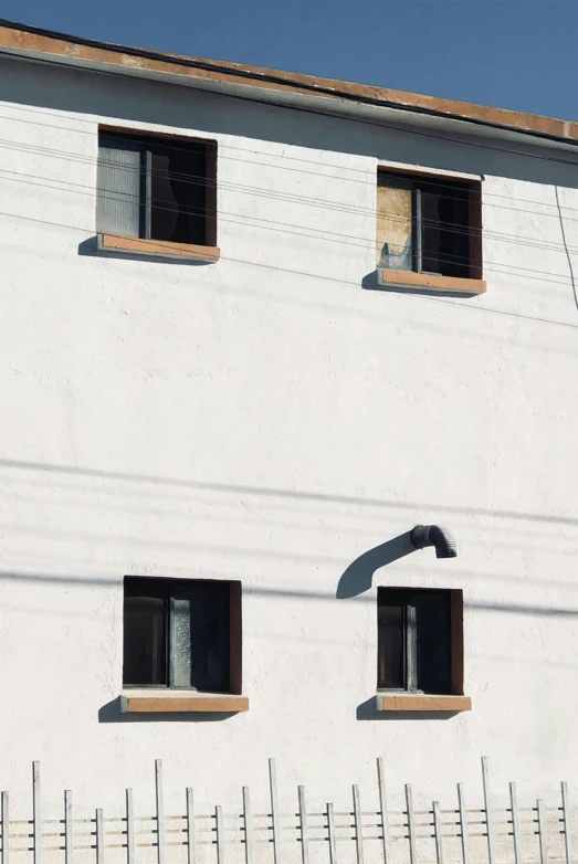 three windows are open on the side of a building