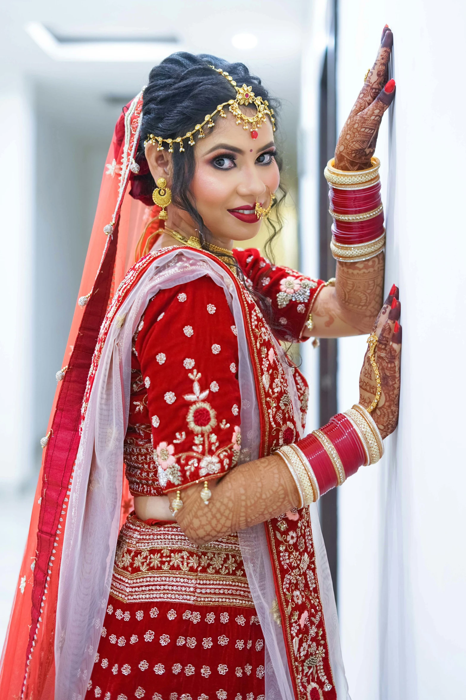 a smiling woman in indian attire and bridal makeup