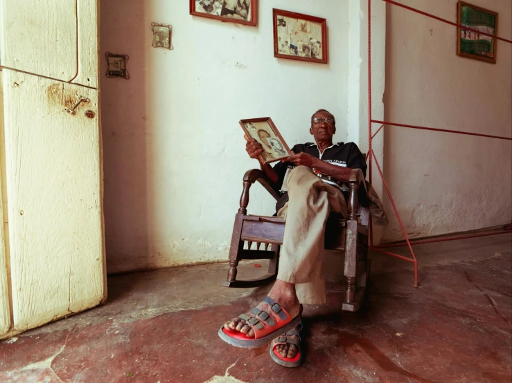 a man sits in a chair holding his picture
