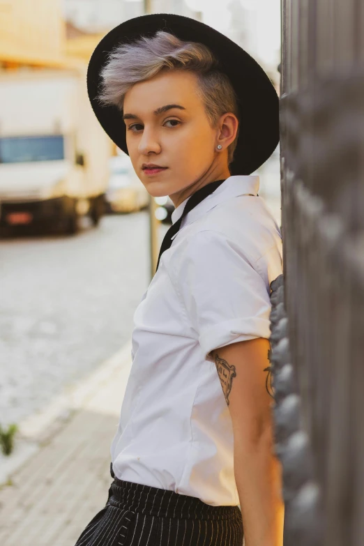 a woman with short gray hair wearing a fedora