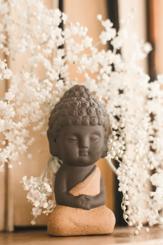 small figurine next to white flowers on table