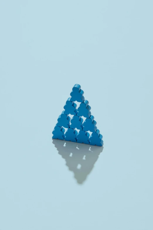 triangle made from toy bricks on blue surface