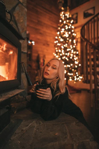 woman sitting near a wood burning fireplace with candles