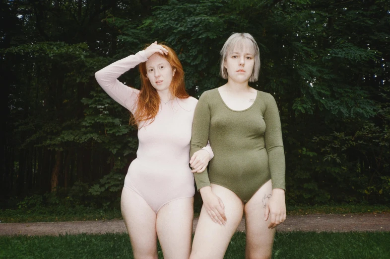 two redheaded women are posed with their hands on their heads