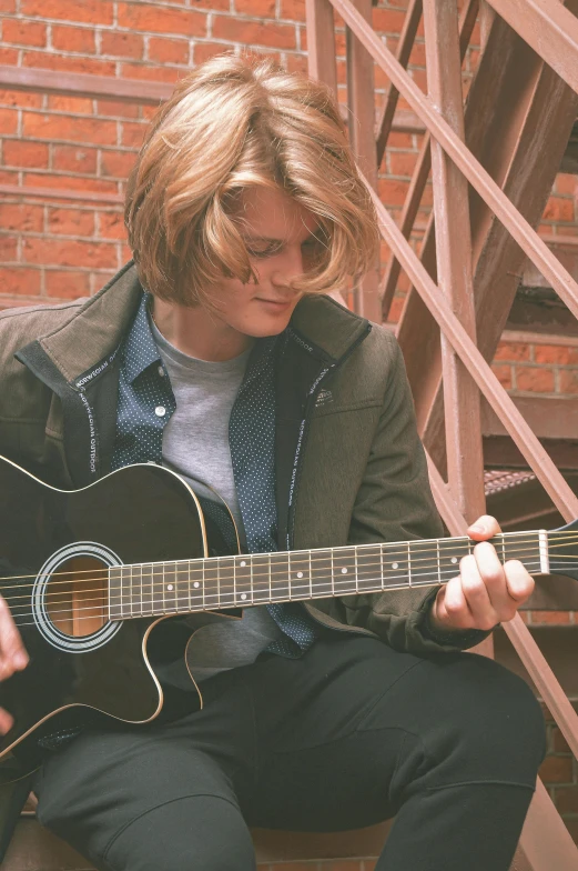 a woman with glasses is playing an acoustic guitar