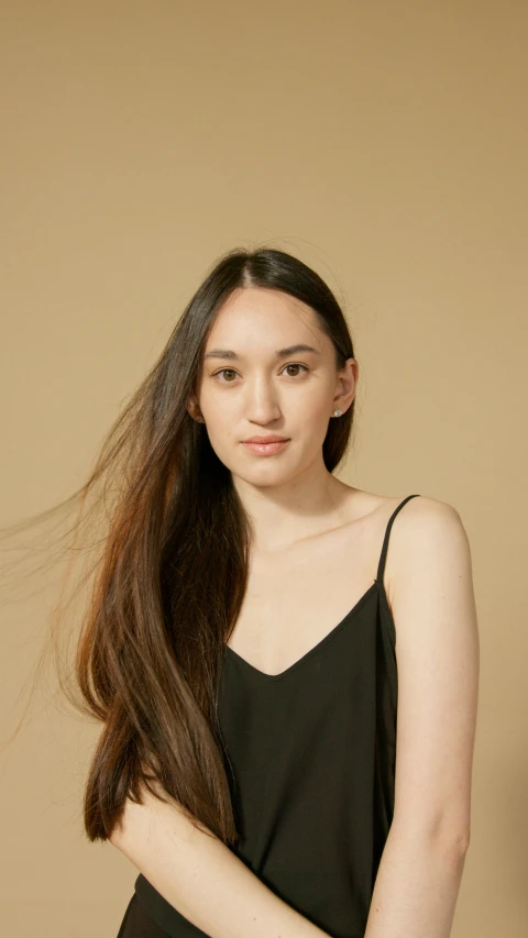 a girl in black tank top standing with long hair