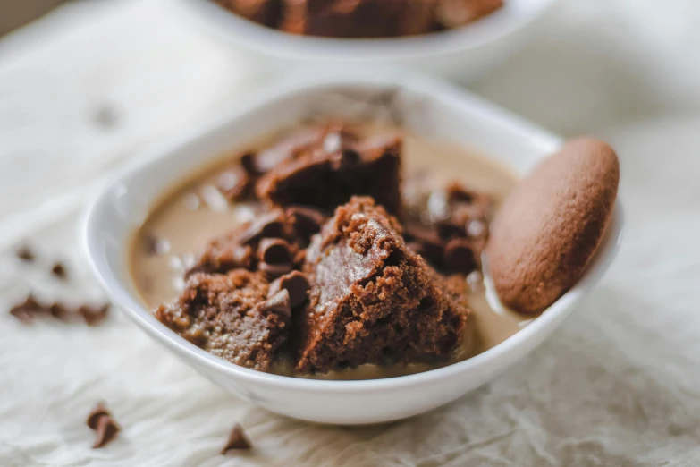 two bowls filled with brownie ding and a chocolate cookie