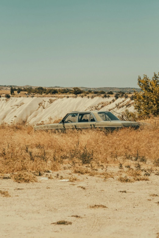 a old car in a deserted area near dunes