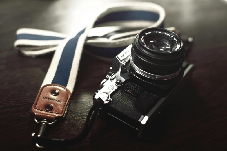 a camera strap is attached to an old camera