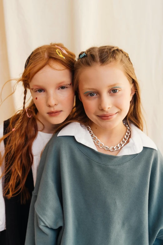 two little girls in identical clothes are posing