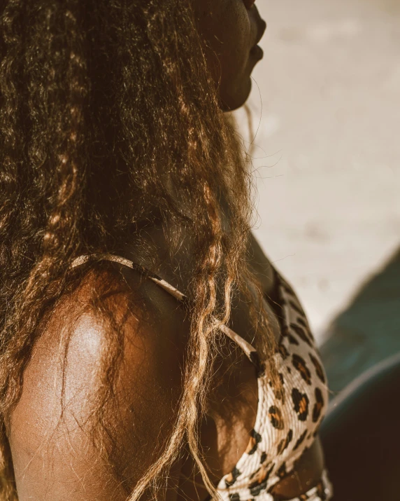 a beautiful woman with a long brown afro and her hair pulled back