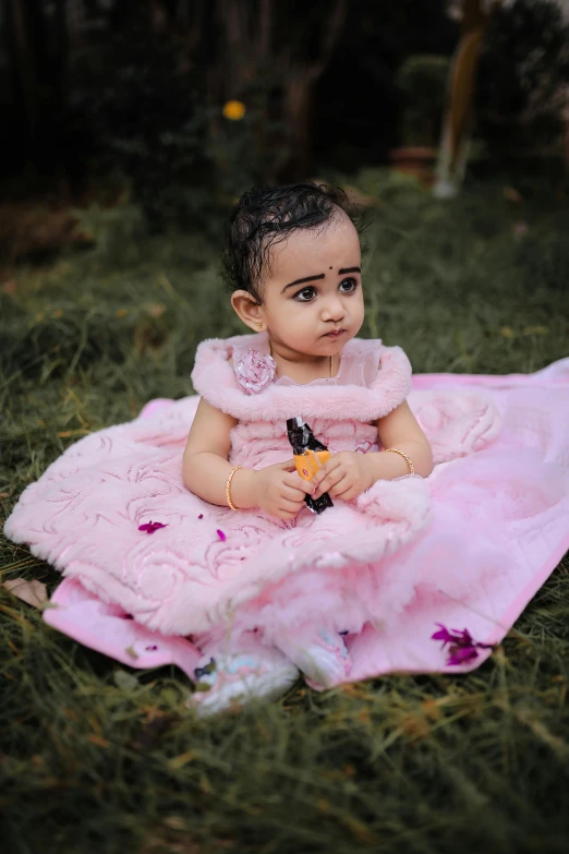 a small toddler sitting on a towel looking to her left