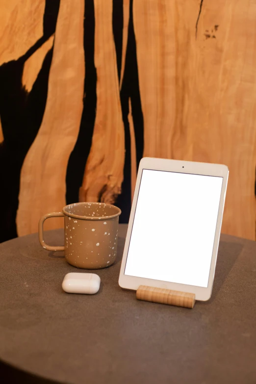 a tablet and mug with some sort of wood carving