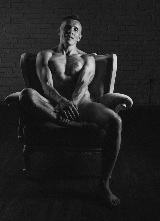 a black and white po of a man sitting in a chair