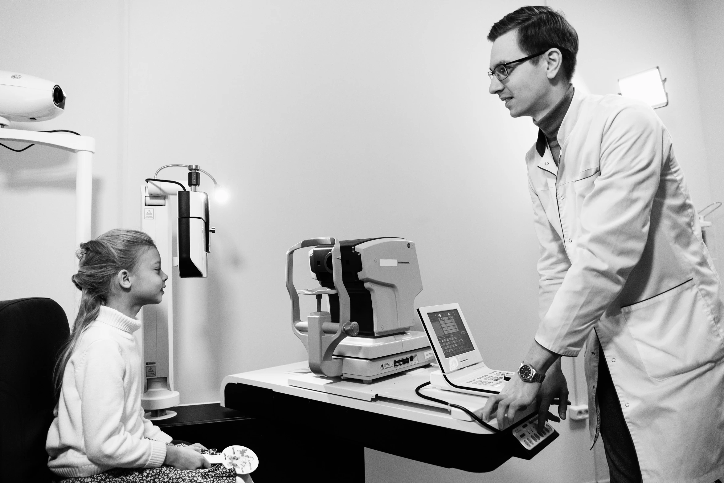 two men in a medical room, one looking at the monitor and the other holding a digital scale