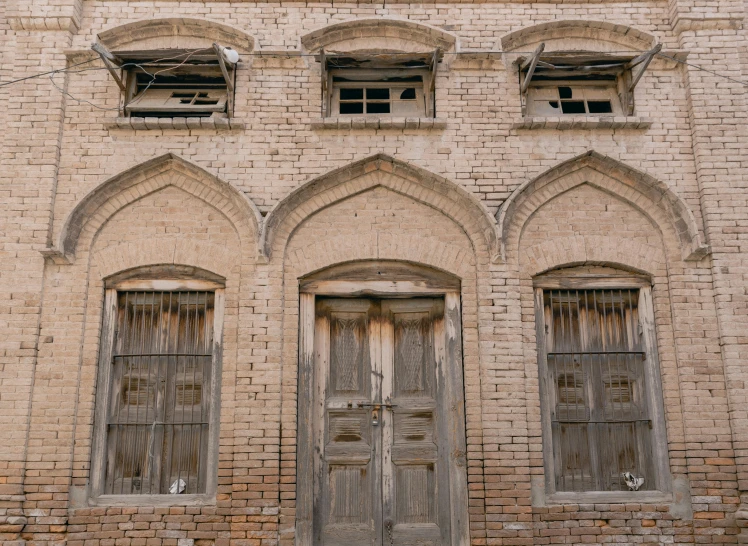a building that has four double doors and two arched windows