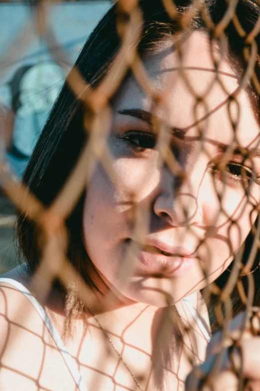 a woman standing behind a fence behind an iron gate