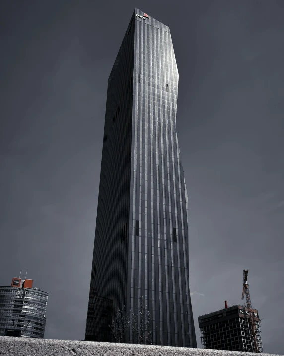 a tall building towering over a city under a dark sky