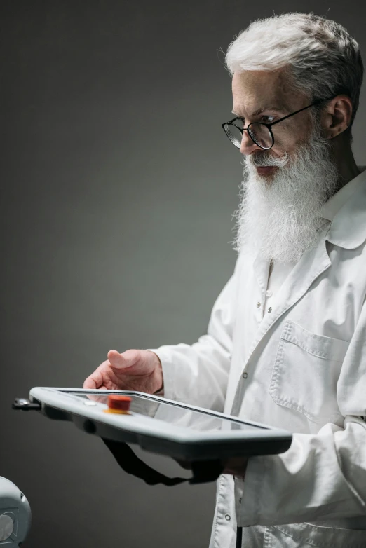 an older man with a beard is using a tablet computer