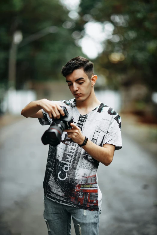 a man in jeans holding a black and white camera