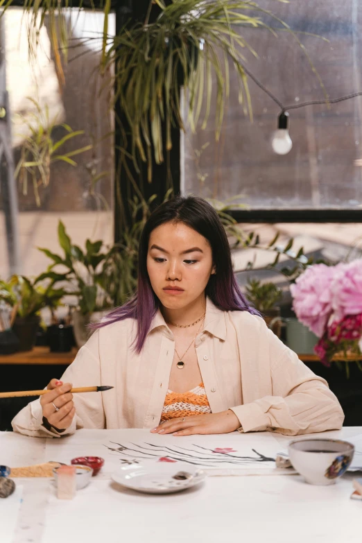 a person at a table with plates and paper