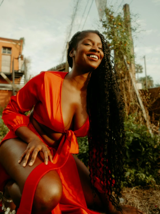 a woman in an orange dress sitting in a garden