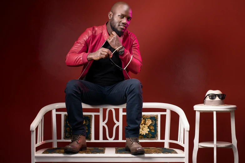 a man in a red leather jacket sitting on a bench