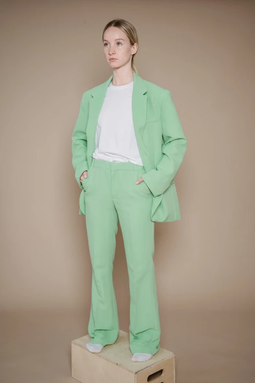 a person wearing a light green suit and white shoes