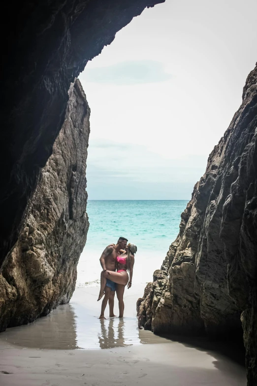 there is a woman hugging another woman at the beach