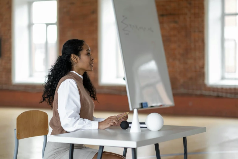 a woman standing next to a laptop on top of a desk