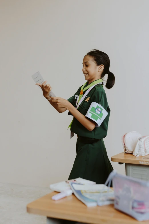 a young woman in green dress holding a piece of paper