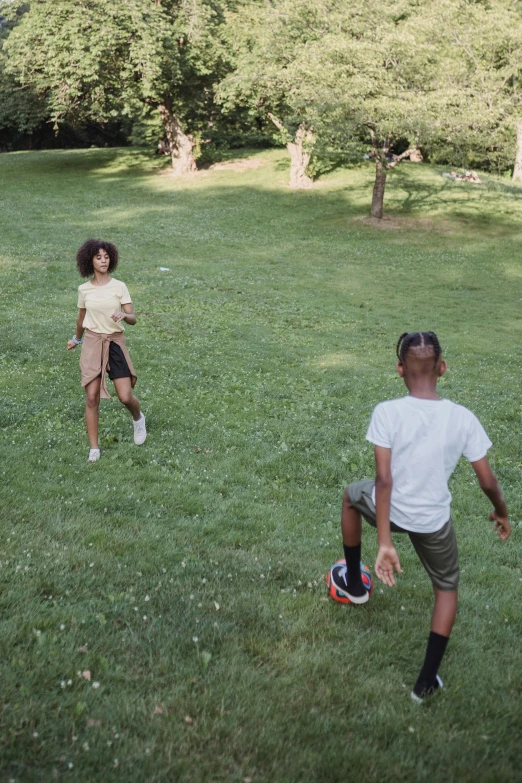 two people are playing frisbee on the grass