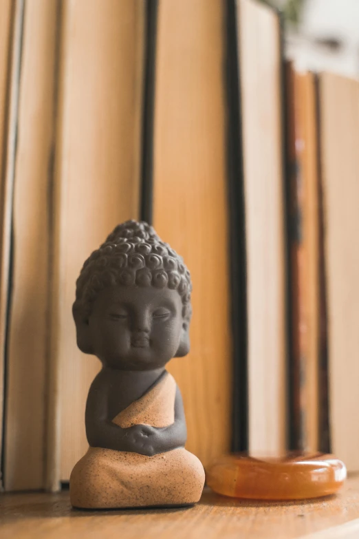 a buddha statue sitting on top of a wooden shelf