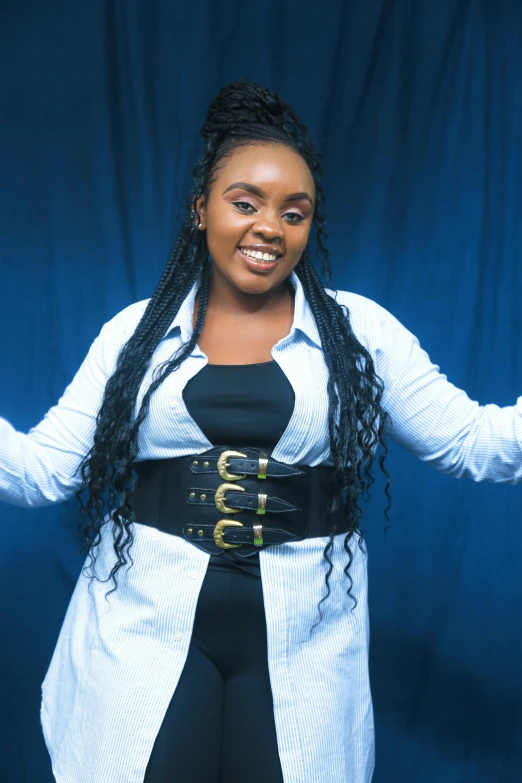 a black woman is smiling and wearing a blue dress