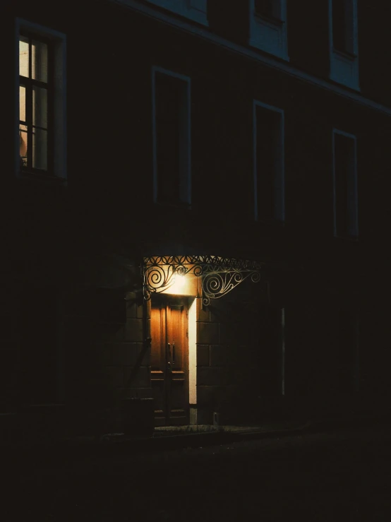 a dark house at night with its lights on and the door open