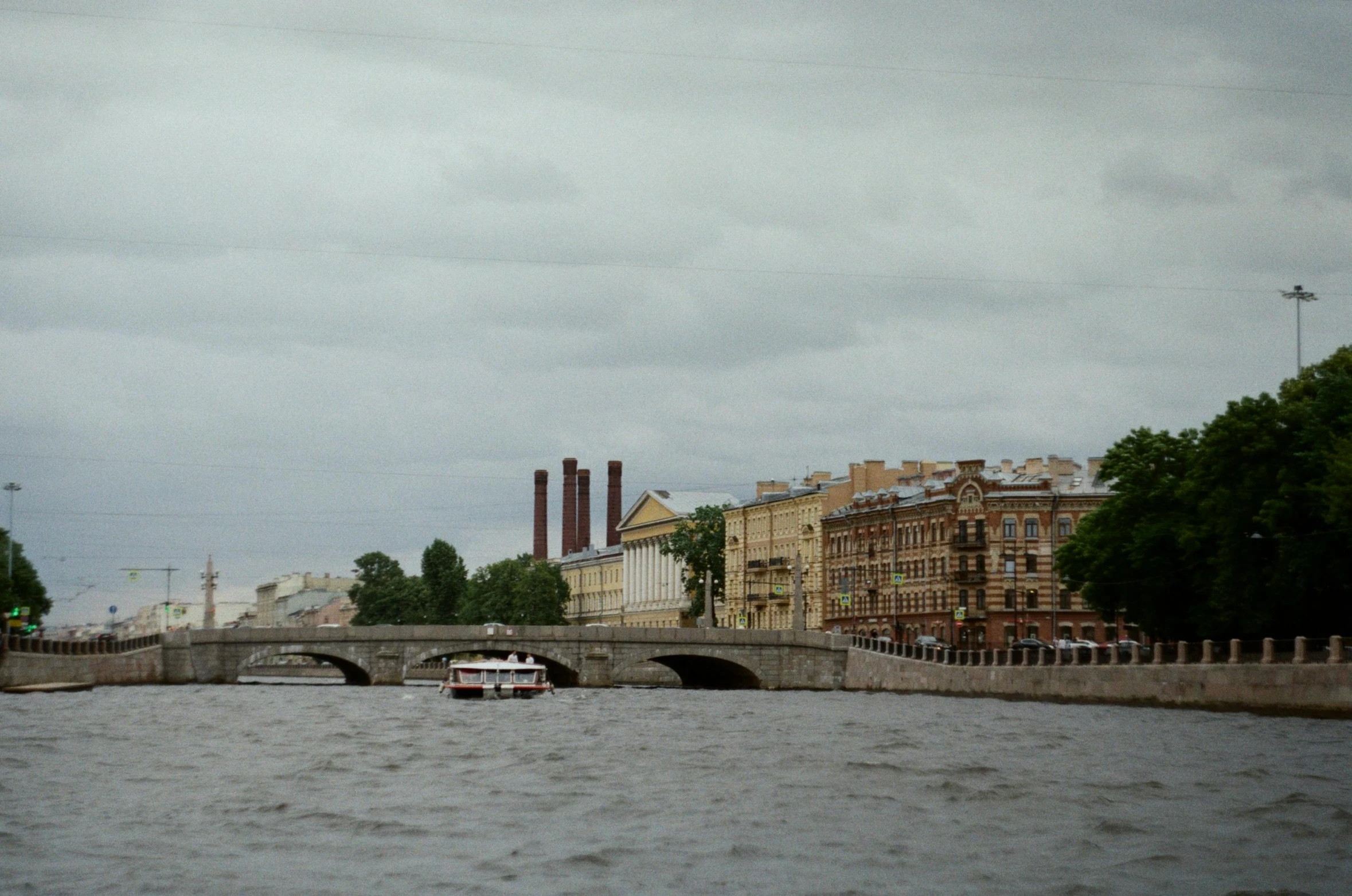 a boat is traveling down the river near a bridge