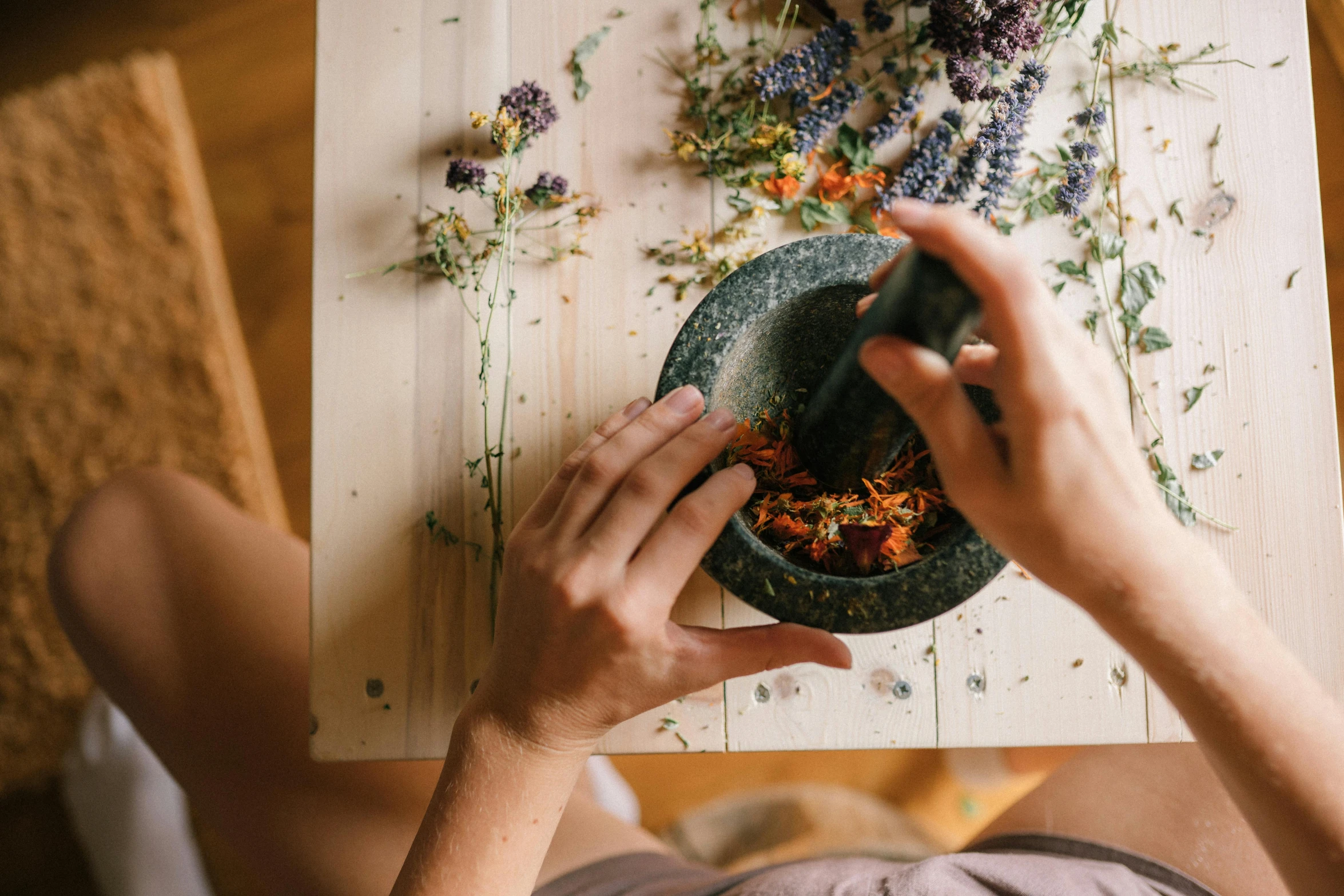 someone preparing food and sitting at a table with a flower wall