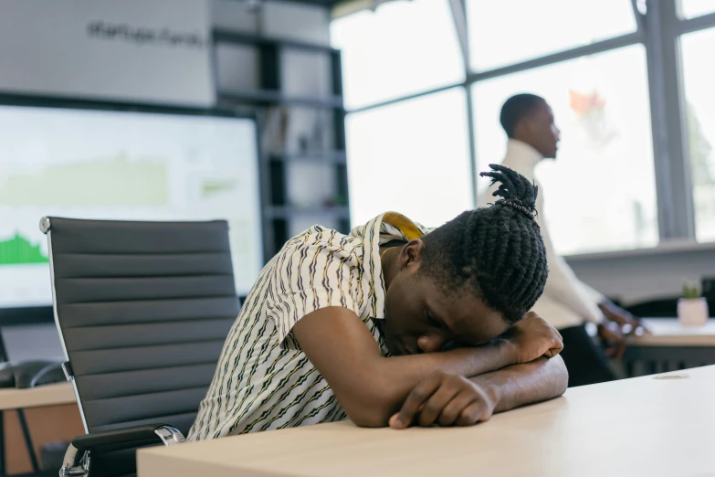 woman asleep in front of a whiteboard in an office